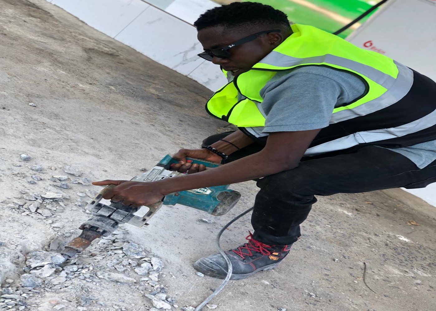 Engineer cutting conduit on the forecourt concrete